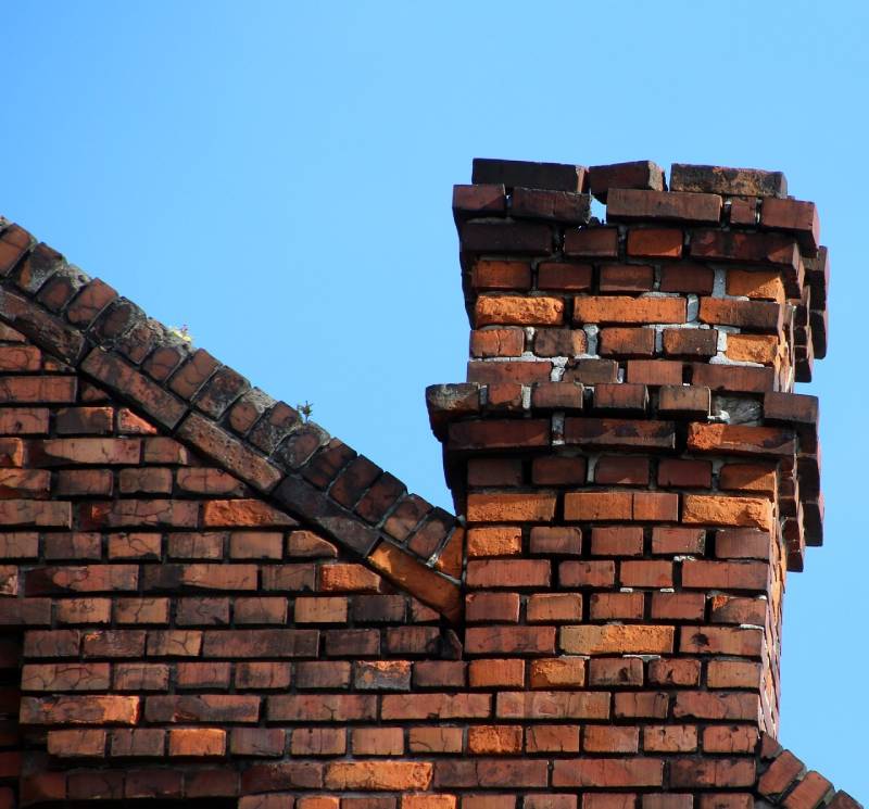 Damaged chimney on an Lake Angelus home showing cracks and missing mortar